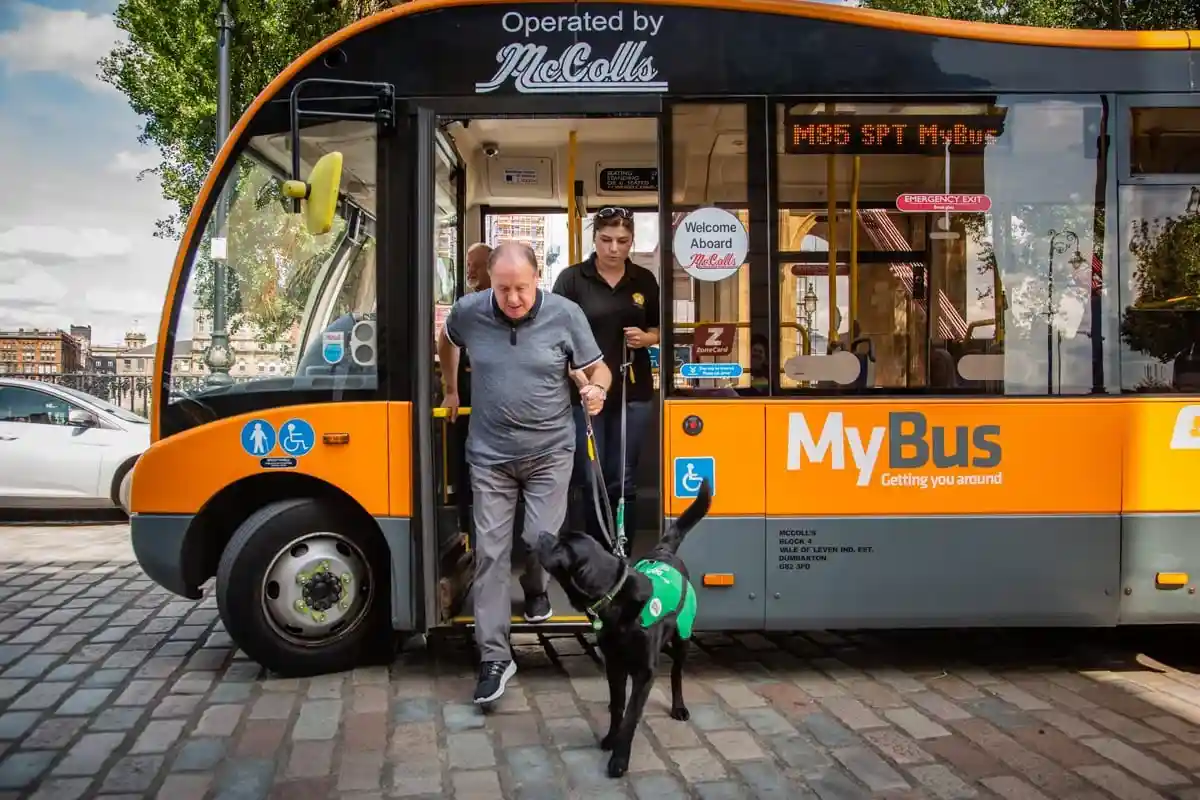 Community Black Labrador Bus Travel Adult Trainer Frontfacing