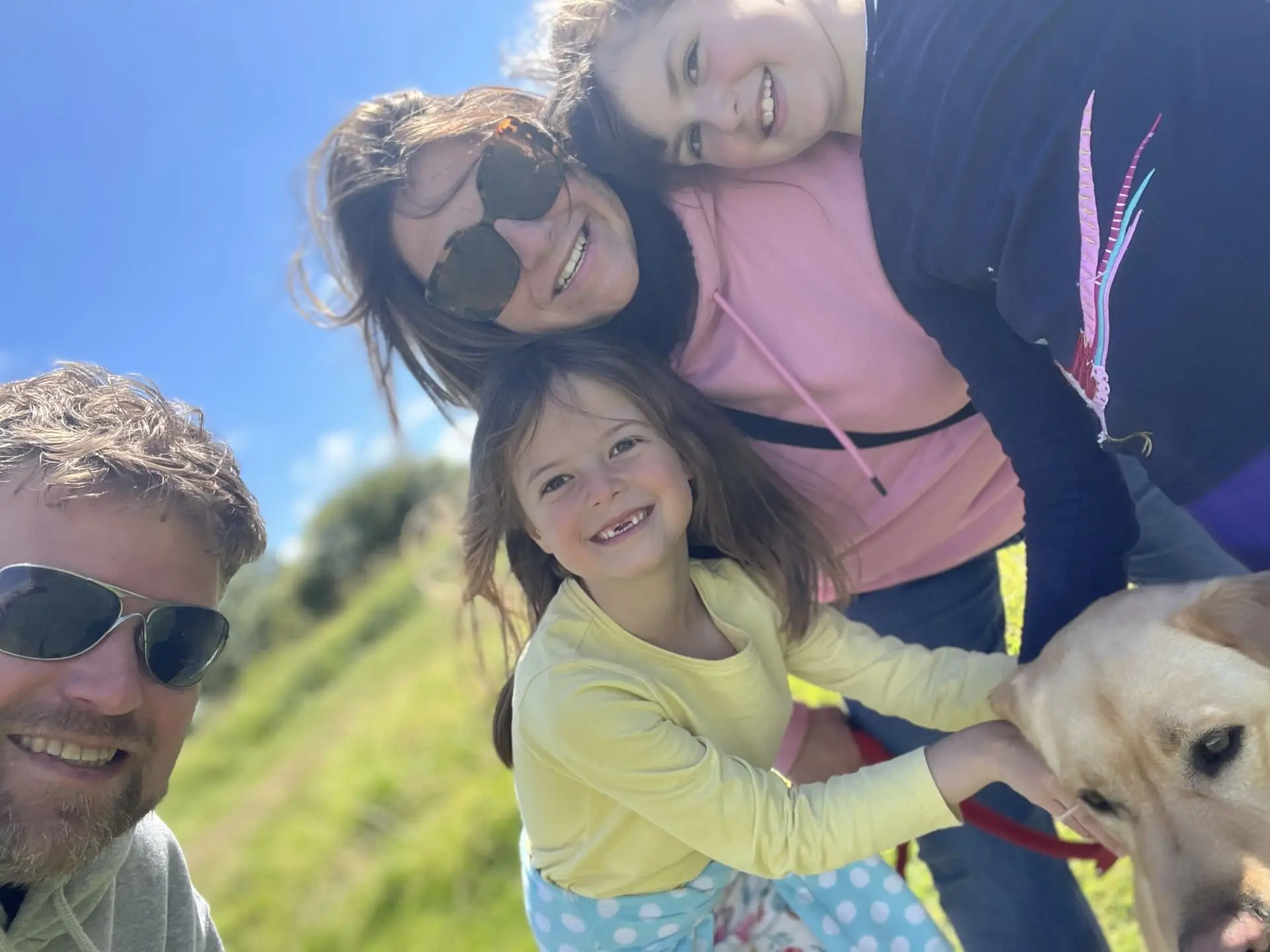 Simon outside in the sunshine with his family and dog