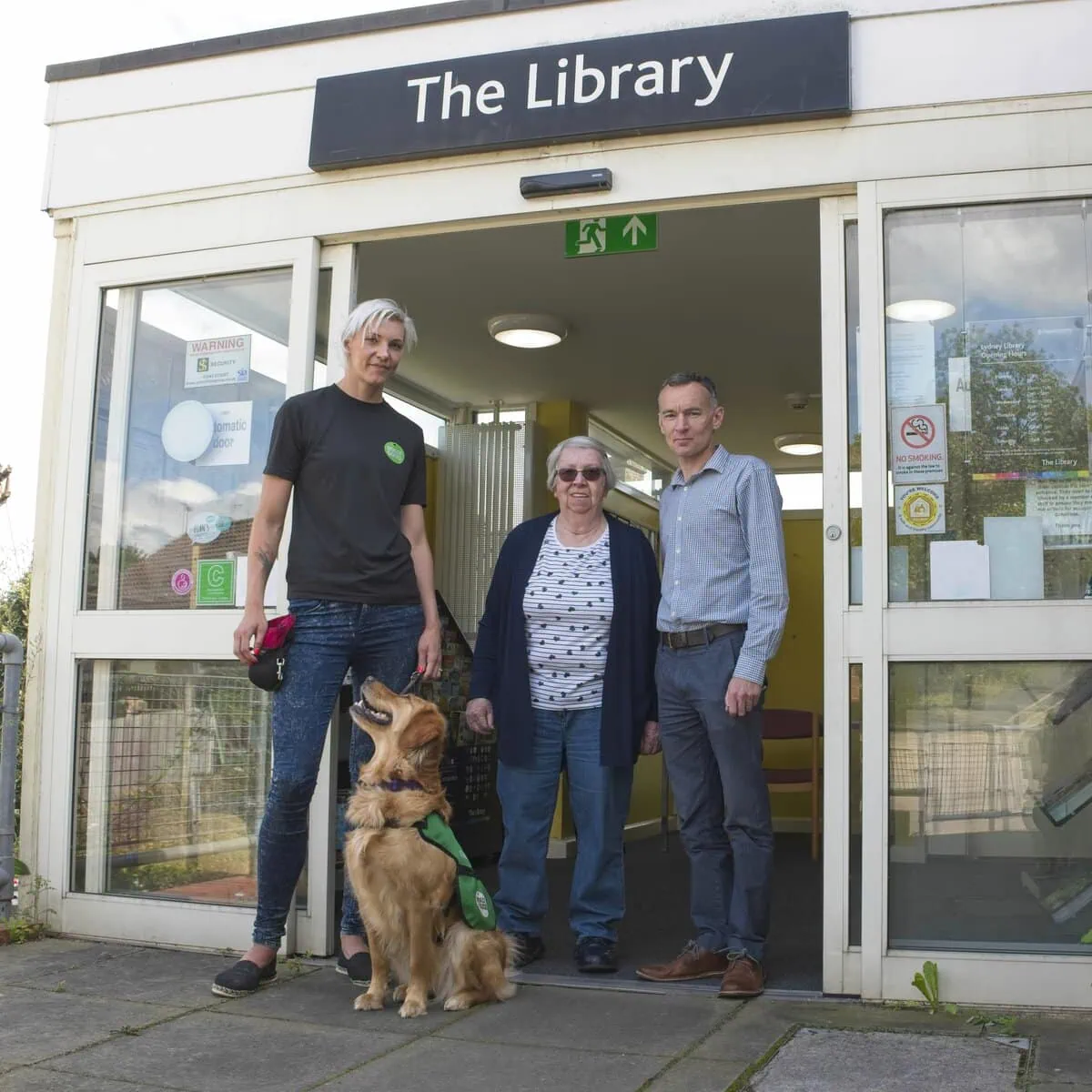Community Golden Retreiver Adults Trainer Outside Library Smiling Frontfacing