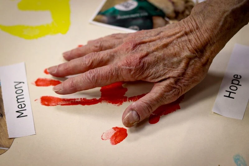 Hand Making A Paint Handprint During A PAWS For Thought Session (1)